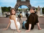 Young couple sitting in front of the Eiffel Tower, direct view, Paris, France, Europe
