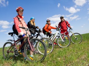 A group of four adults on bicycles in the countryside