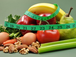 Group of wholesome, organic food, including pear, apple, tomato, eggs, nuts, pecans, walnuts, carrot, banana, and apple, for a healthy diet or slimming New Year resolution.